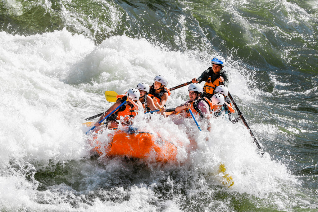 Whitewater Rafting Near Missoula 1 A family is on an orange zoo town surfers raft enjoying whitewater rafting near missoula on the alberton gorge river.