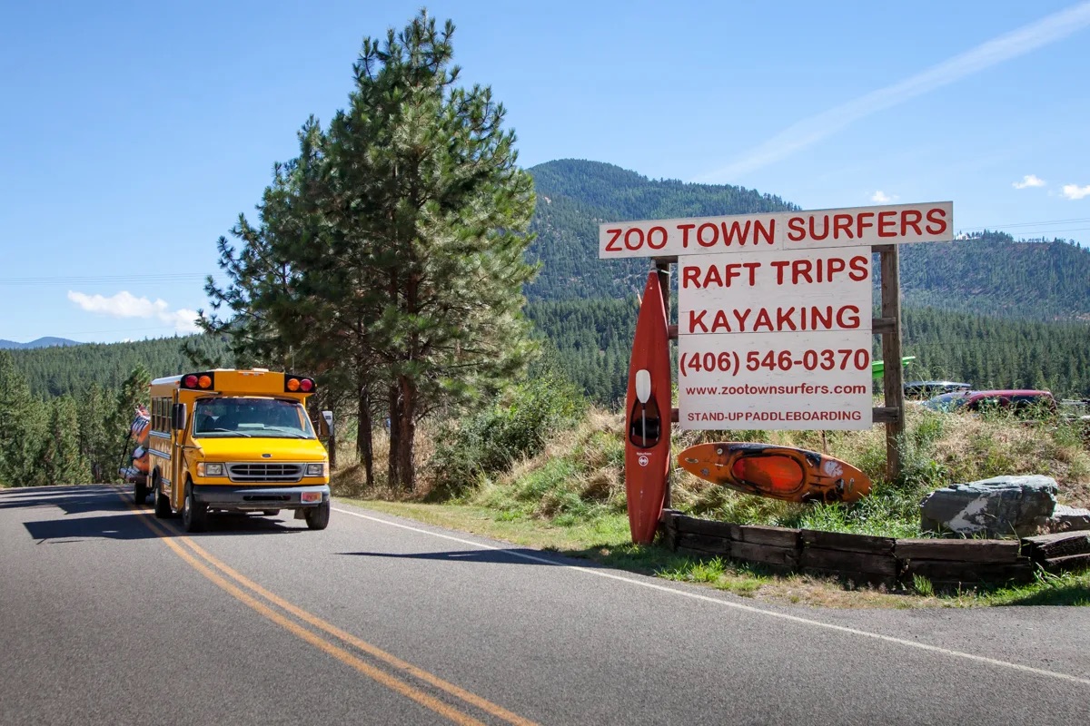 Zoo Town Surfers roadside sign with kayaks and shuttle bus