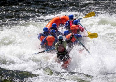 Rafters paddling hard as they ride a big wave on the Lochsa River.