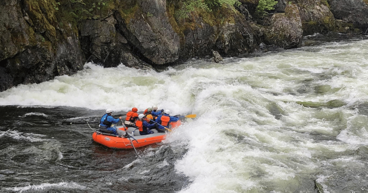 A raft crew paddling into a powerful rapid on the Lochsa River, surrounded by Idaho’s rugged wilderness.