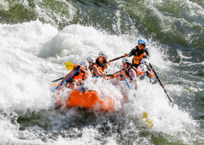 Rafters on a guided trip powering through a whitewater rapid on the Alberton Gorge near Missoula.
